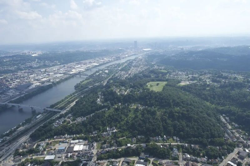 Aerial view of Pittsburgh's river, neighborhoods, roads, and wooded hills